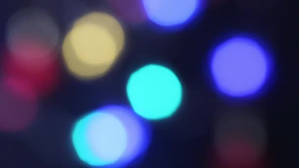 Dari fokus warna-warni kabur meriah lampu bergerak di latar belakang hitam — Stok Video