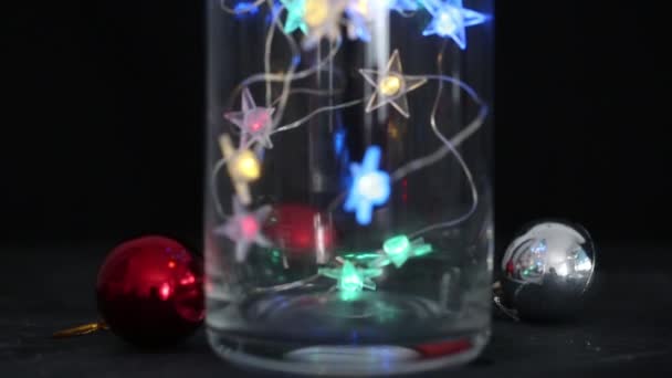 Festiwalowe dekoracyjne lampki gwiazdkowe, zakładające szklaną wazę w nocy. Ciepłe oświetlenie, vintage girlanda lamp lub lampy szklane — Wideo stockowe