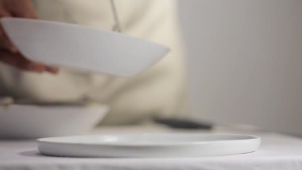 Chef colocando pasta de tinta de sepia negra con salsa carbonara en un plato de porcelana — Vídeos de Stock