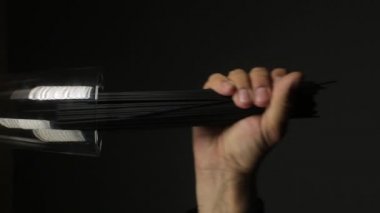 Adam mürekkep balığı spagettisini koyu siyah arka plana koyar, dikey videoyu kapatır.