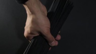 Adam mürekkep balığı spagettisini koyu siyah arka plana koyar, videoyu kapatır.