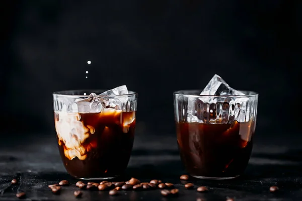 Wlewanie mleka do szklanki kawy espresso z lodem — Zdjęcie stockowe