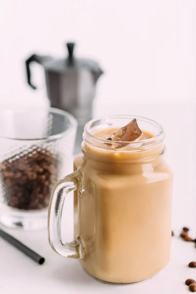 Café glacé en pot, tasse en verre sur la table blanche . — Photo