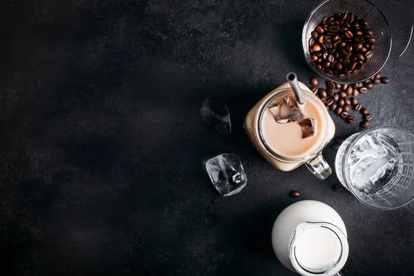 Koude ijskoffie met ingrediënten: ijsblokjes, melk, koffiebonen — Stockfoto