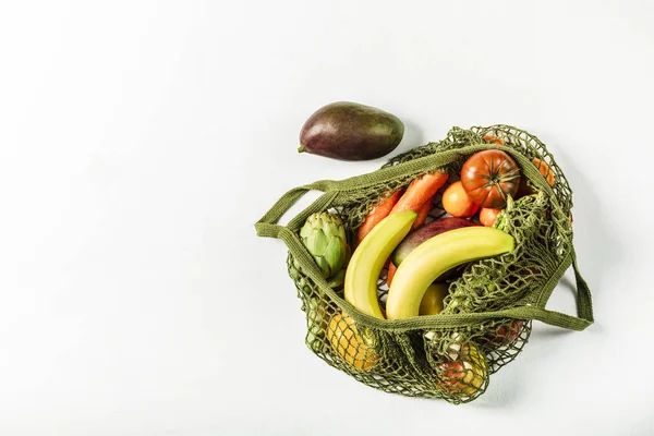 Verduras frescas y frutas en una bolsa de hilo verde en un bac blanco —  Fotos de Stock