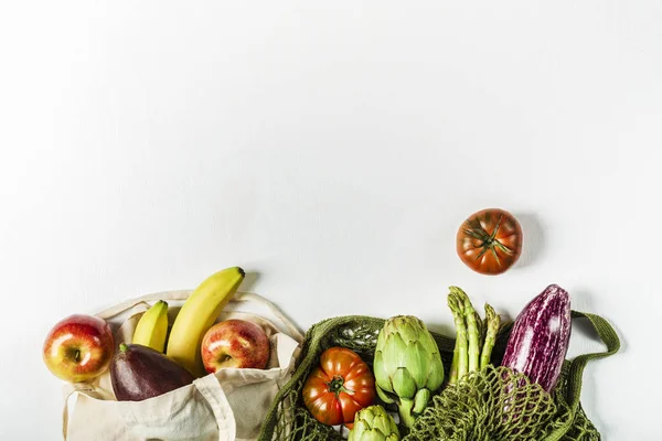 Świeże warzywa w zielonym woreczku strunowym i owoce w torbie — Zdjęcie stockowe