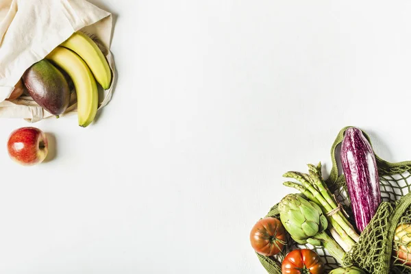 Verduras frescas en una bolsa de hilo verde y fruta en una bolsa hecha de materiales naturales —  Fotos de Stock