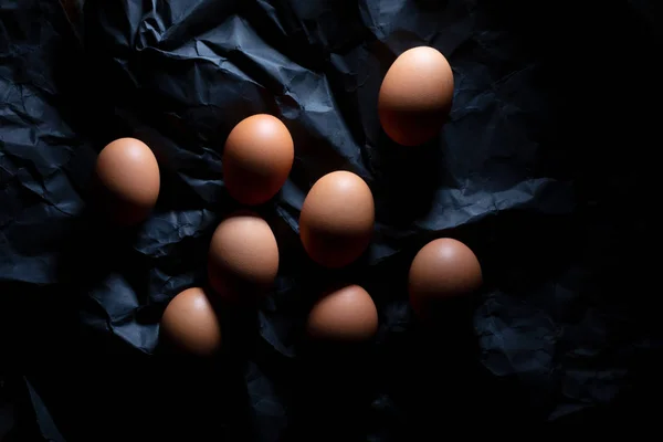 Вісім коричневих яєць на темному тлі для розфарбування — стокове фото