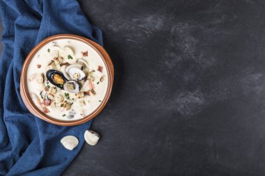 Kahverengi tabakta deniz tarağı çorbası. Ana malzemeler kabuklu deniz ürünleri, et suyu, tereyağı, patates ve soğan..