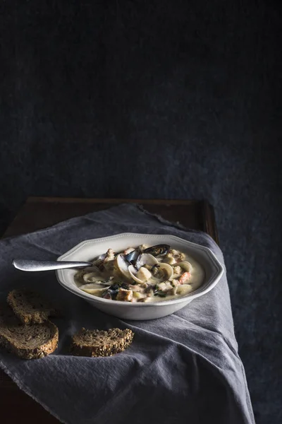 Zuppa di vongole in un piatto bianco. Gli ingredienti principali sono crostacei, brodo, burro, patate e cipolle. . — Foto Stock