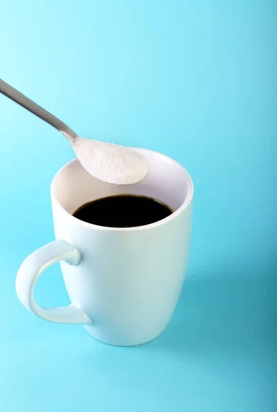 Caffè del mattino e un cucchiaio con polvere di collagene su sfondo blu . — Foto Stock