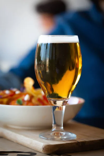 Vaso de cerveza y patatas fritas en mesa de madera —  Fotos de Stock