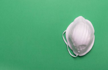 Koronavirüs önleyici yeşil arka planda Covid-19 koruyucu maske