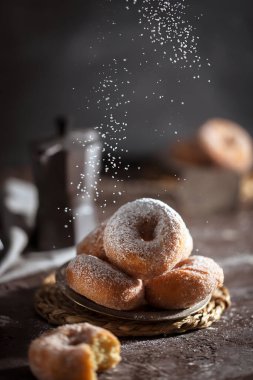 Koyu arkaplanda şeker tozu olan çörekler