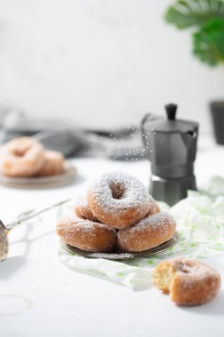 Beyaz zemin üzerinde şeker tozu olan çörekler