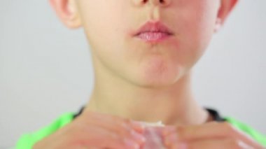 Çocuk kırmızı elmayı ısırıyor ve çiğniyor.