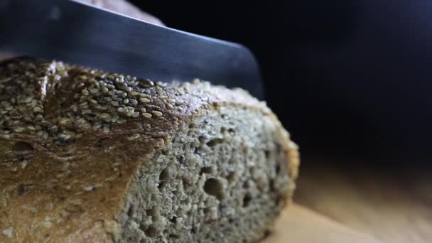 Man Gesneden Ontbijtgranen Brood Een Houten Tafel Een Donkere Achtergrond — Stockvideo