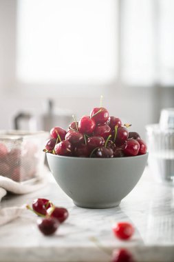 Beyaz masadaki kirazlar kahvaltı için hazır.