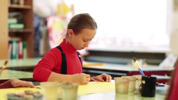 La ragazza disegna un quadro dipinge in classe — Video Stock