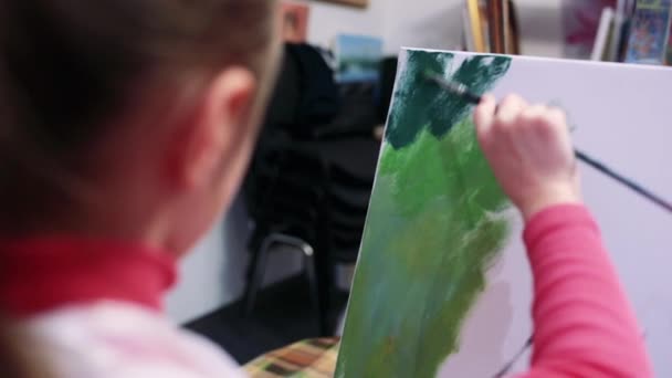 Flicka konstnär målar med olja på staffli. — Stockvideo