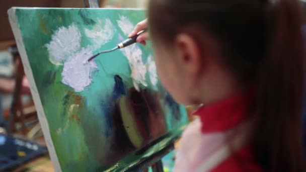 Flicka konstnär målar med olja på staffli. — Stockvideo