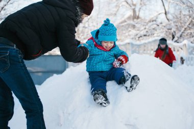 sıcak giyinmiş çocuk karlı bir tepe üzerinde sürme