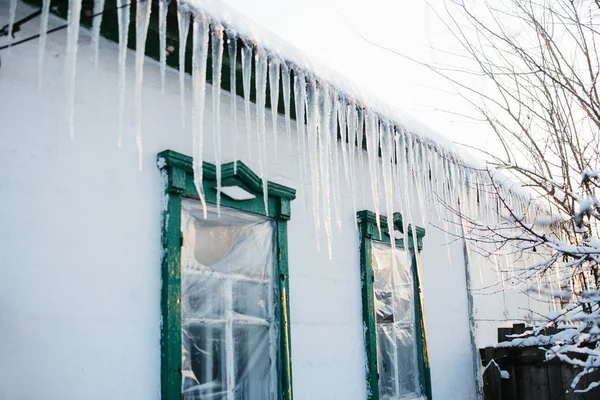 Eiszapfen auf Dach lizenzfreie Stockbilder