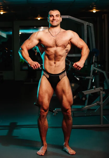 Pria tampan dengan otot besar, berpose di kamera di gym — Stok Foto