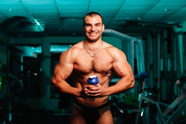 Jóképű férfi nagy izmokkal, pózol a kamera előtt az edzőteremben — Stock Fotó