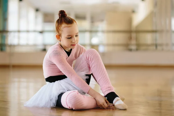 Девушка-балерина ест банан в балетном классе — стоковое фото