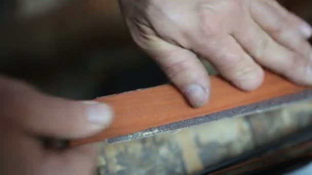 Strong hands grind a wooden plank for cue — Stock Video