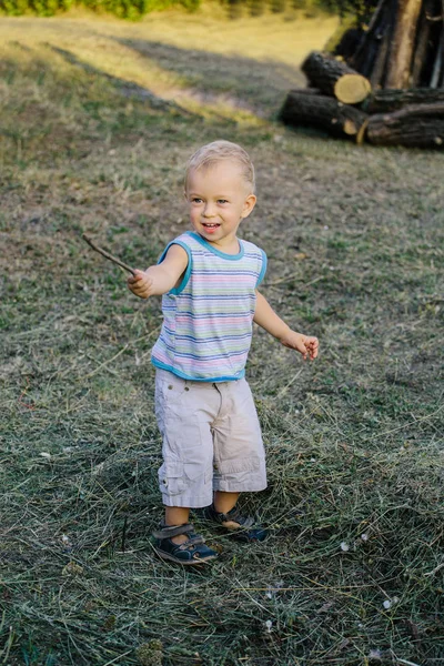 Een jongen loopt langs een open plek in het gras — Stockfoto