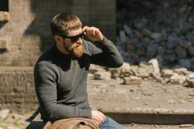 Bir tuğla duvarın üzerinden Kızıl saçlı erkek.