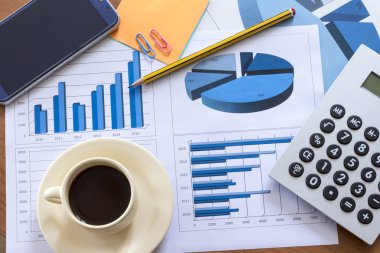 Dosyaları, histogramları ve finansal belgeleri olan ofis masası.