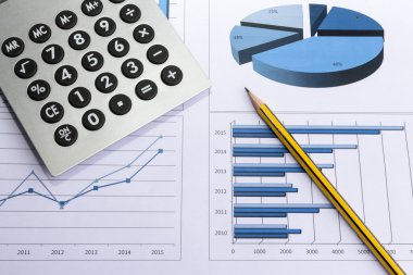 Dosyaları, histogramları ve finansal belgeleri olan ofis masası.