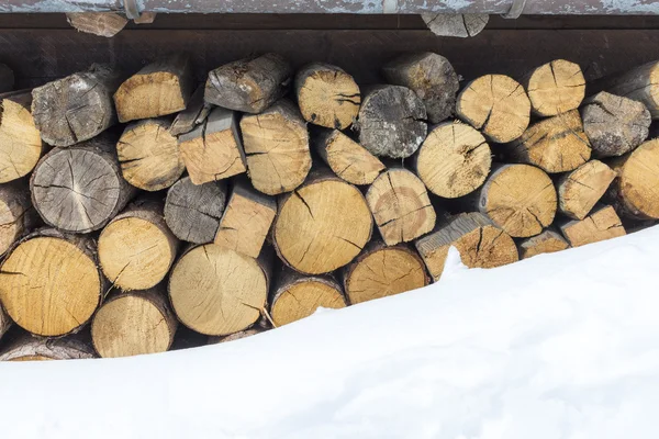 Nahaufnahme eines Brennholzstapels, der mit Schnee bedeckt ist lizenzfreie Stockfotos