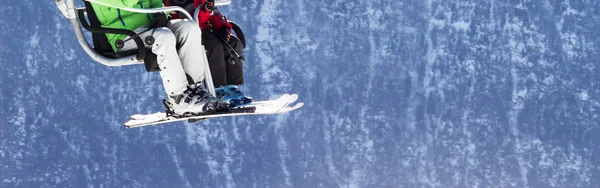 Esquiadores en telesilla con montañas nevadas en el fondo —  Fotos de Stock