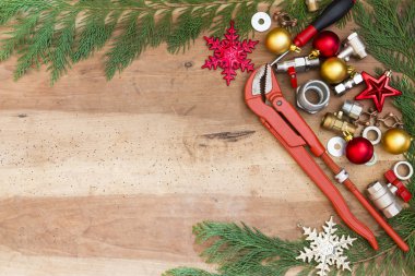 tesisatçılık araçları, bağlantı parçaları ve Noel dekorasyonları ahşap arka plan üzerinde