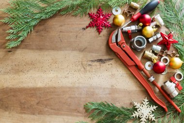 tesisatçılık araçları, bağlantı parçaları ve Noel dekorasyonları ahşap arka plan üzerinde