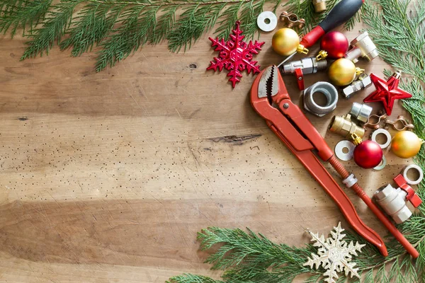 tesisatçılık araçları, bağlantı parçaları ve Noel dekorasyonları ahşap arka plan üzerinde