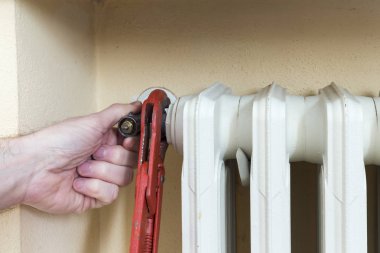 Tesisatçı termostatik vana bir radyatör üzerinde yükleme iş başında