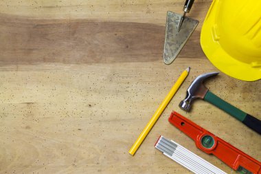 Ahşap arka plan üzerinde koruyucu kask ve mason araçları