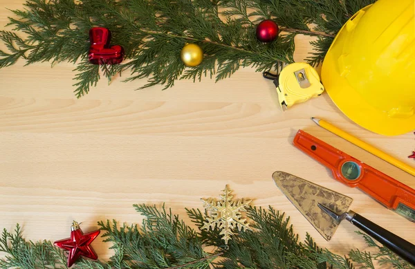 Koruyucu kask, mason araçları ve Noel dekorasyonları ahşap arka plan üzerinde