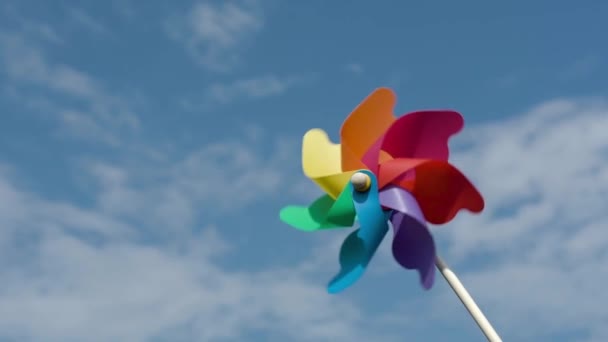 Färgat papper skruv roterar mot en blå himmel, slow motion — Stockvideo