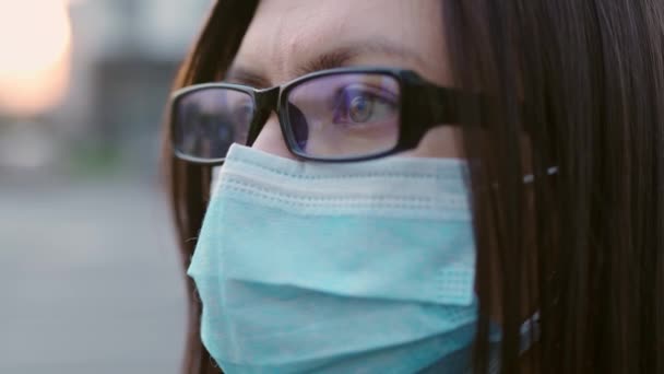 Ojos cercanos de una chica con gafas y una máscara médica . — Vídeo de stock