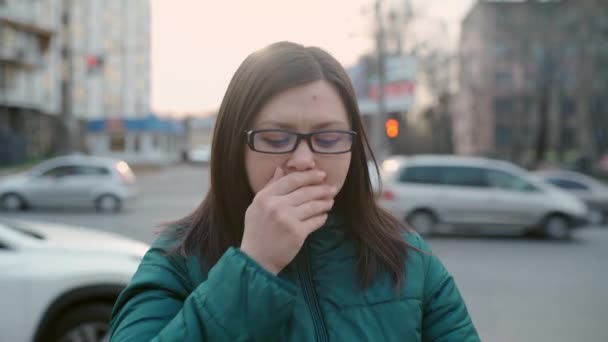 Mladá dívka kašle na ulici a nasazuje si lékařskou masku. lékařská koncepce. — Stock video