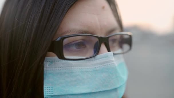 Närbild ögon av en flicka i glasögon och en medicinsk mask. — Stockvideo
