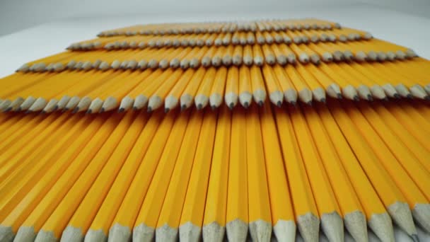 Många gula pennor ligger i rader. Makrofotografering med 24 mm Laowa-lins — Stockvideo