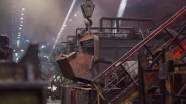 Çelik Fabrikası. Büyük bir vinç erimiş metal kepçesini taşıyor..