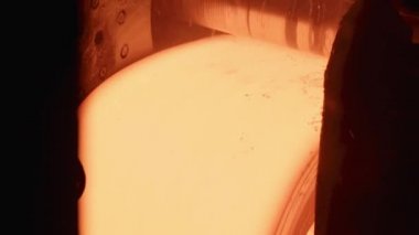 Taşıyıcı üzerinde kırmızı-sıcak metal levha döner. Yavaş hareketler.